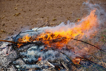 Bright orange and yellow flames are visible rising from the burning materials.