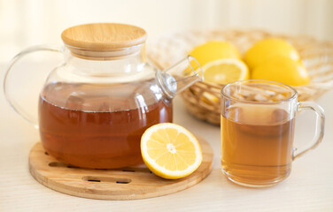Tea with slice of lemon and honey on wooden table and blue background