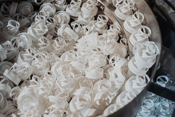 Mass production of caps for pharmaceutical containers. White plastic caps at a packaging factory....