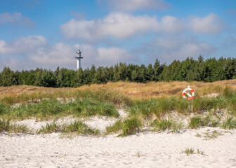 Lighthouse and lifebuoy at Dueodde beach on the island Bornholm, Denmark.