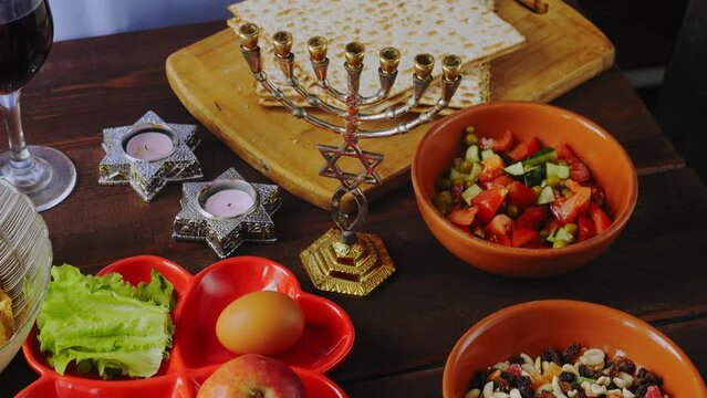A festively laid Pesach Seder table with matzo candles, food and wine. General plan