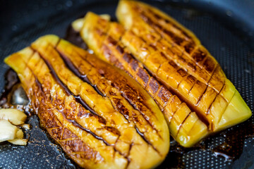 Delicious grilled eggplants with garlic on the fried pan