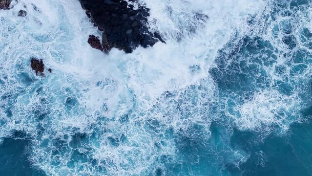 Aerial view of ocean waves, crushes around the rocky and scenic coastline with foam. Coastline Of Madeira island in Atlantic ocean