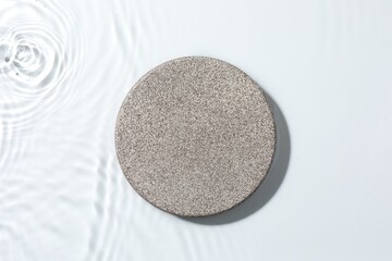 Presentation for product. Stone podium in water on white background, top view