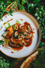 A close-up of a plate of roasted beef slices drizzled with brown sauce and served with tomato wedges.