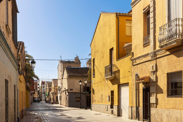 Valencia, Spain - 24 March 2024: Old multi-colored houses in the Cabanyal district, considered disadvantaged. Street Carrer de Carles Ros