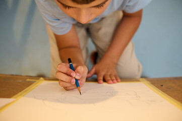 Child drawing in art class, creativity and imagination fostered by hands-on learning