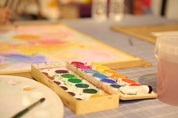 Fototapeta premium Kids enjoying an art class, drawing and painting with their teacher in a creative workshop setting