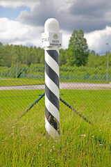 Estnischer Grenzpfahl an dem Innerstädtischen Grenzübergang zwischen Estland und Lettland in der Stadt Valka / Valga.