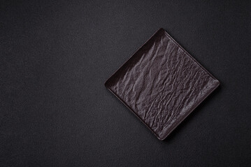 Empty ceramic round plate on dark textured concrete background