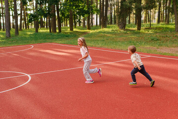 Fototapeta premium little girl and boy running in the park, healthy lifestyle