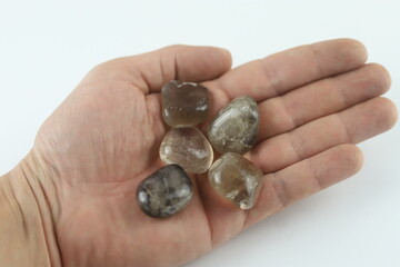 Hand holding smoky quartz crystals for healing and meditation. Hand is holding several smoky quartz...