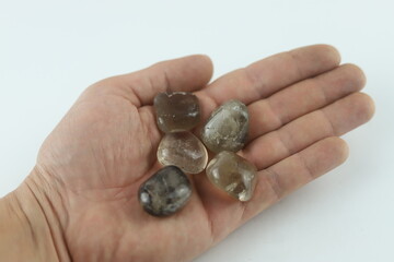 Hand holding smoky quartz crystals for healing and meditation. Hand is holding several smoky quartz...