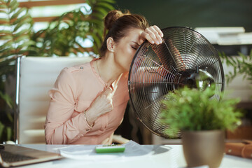 modern woman worker at work suffering from summer heat