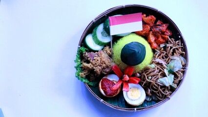 Tumpeng merah putih, yellow cone shaped rice decorated with red and white ribbon served during Indonesia independence day celebration on August 17, white background