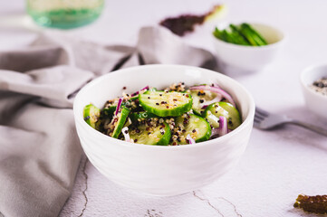 Vegetarian salad of quinoa, cucumber and red onion in a bowl on the table
