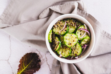 Close up of vegetarian salad of quinoa, cucumber and red onion in a bowl on the table top view