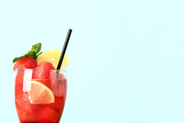 Glass of fresh watermelon lemonade with mint on turquoise background
