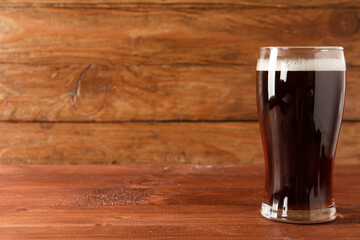 Glass of tasty kvass on wooden background