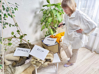 Middle-Aged Blogger Woman shoots on a smartphone Sorting Belongings With KonMari Method. Mature woman categorizes items