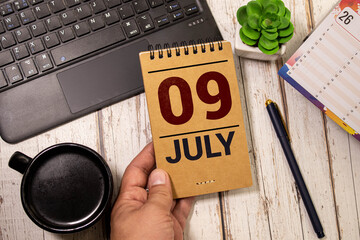 July 9 calendar date text on wooden blocks with blurred background park.