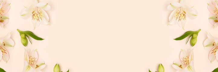 Frame made of white alstroemeria flowers and green leaves on a beige background. Banner with copy space.