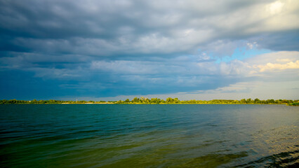 blue lake before a thunderstorm with dark clouds