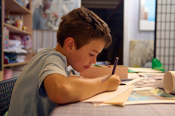 Young boy focused on drawing during art class in a workshop