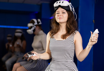 Cheerful teen girl with VR headset and controllers, eagerly anticipating virtual reality experience...