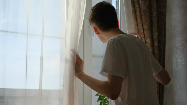 A young man who escaped looked out the window and pulled back the curtains