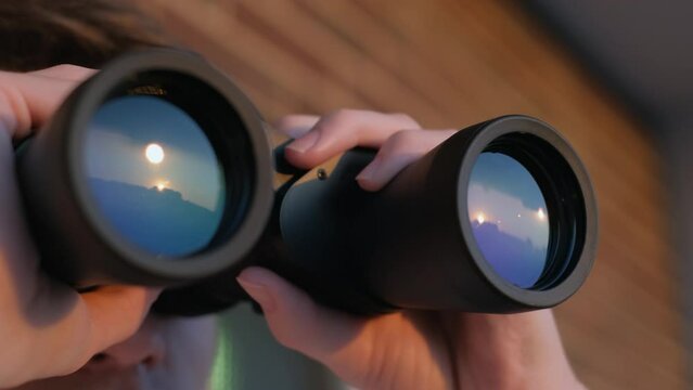 Man looking through binoculars close up