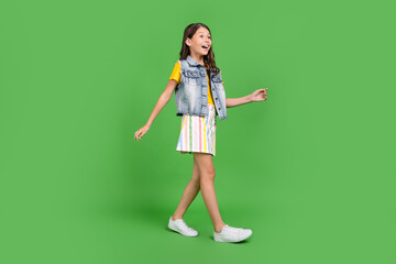 Photo of positive kid go walk profile side isolated green color background