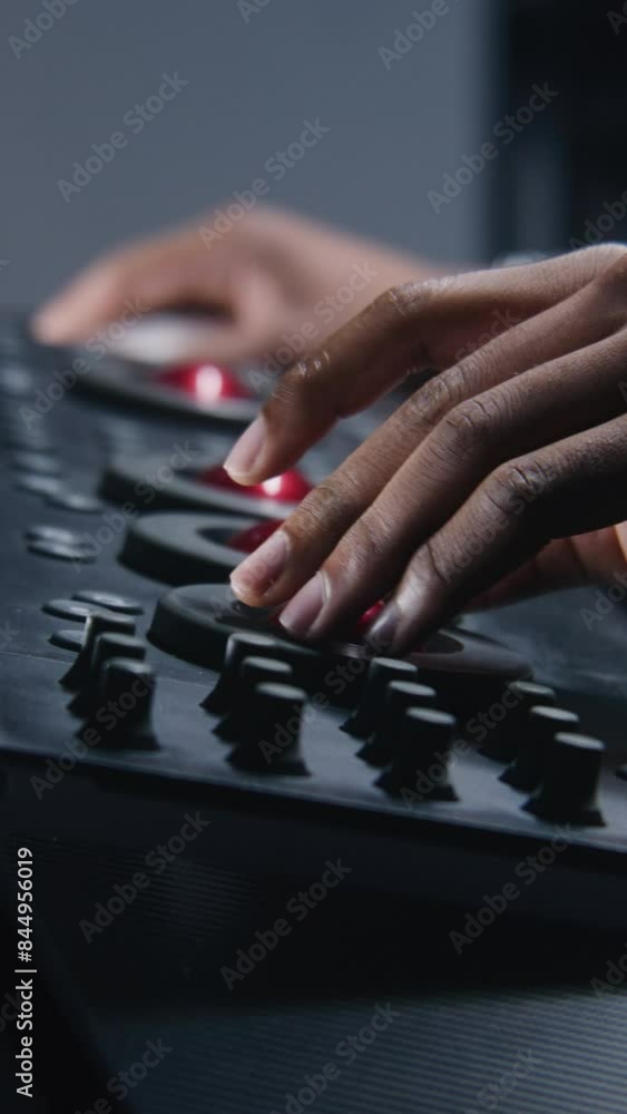 Poster hands close up of african american colorist working by color grading control panel in studio with mo