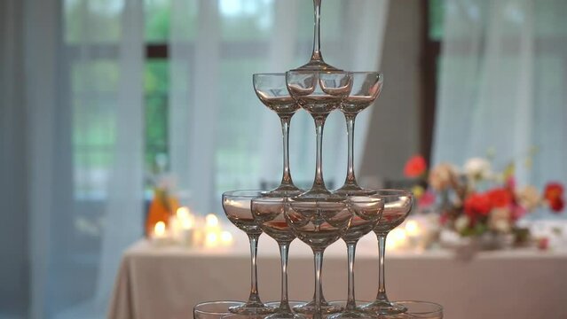 Tower of glasses at celebration party. Welcome drinks, tower of champagne or sparkling wine. Empty with red berry. Restaurant ready for reception. Alcoholic beverage.