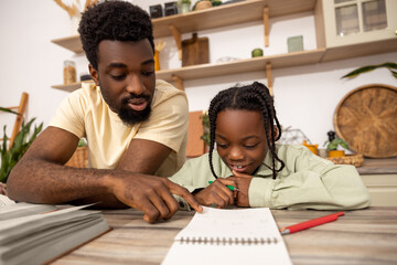 African American man helping her daughter with lessons
