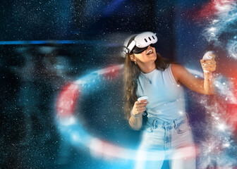 Young woman in VR headset with controllers in hands interacting with virtual reality environment against colorful abstract background, enhancing sense of immersion, creating futuristic atmosphere..