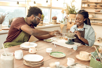 Two people looking involved while working with new pottery