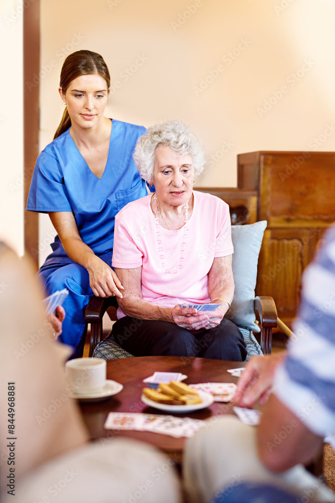 Wall mural Nursing home, nurse and senior patient with playing cards for games, fun and serious women. People, caregiver and concentrate with bonding for care, support and trust in healthcare for entertainment