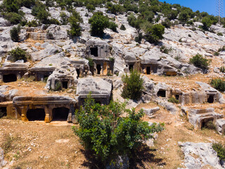 View of stone ruins of rock necropolis in ancient city of Limyra on sunny spring day....