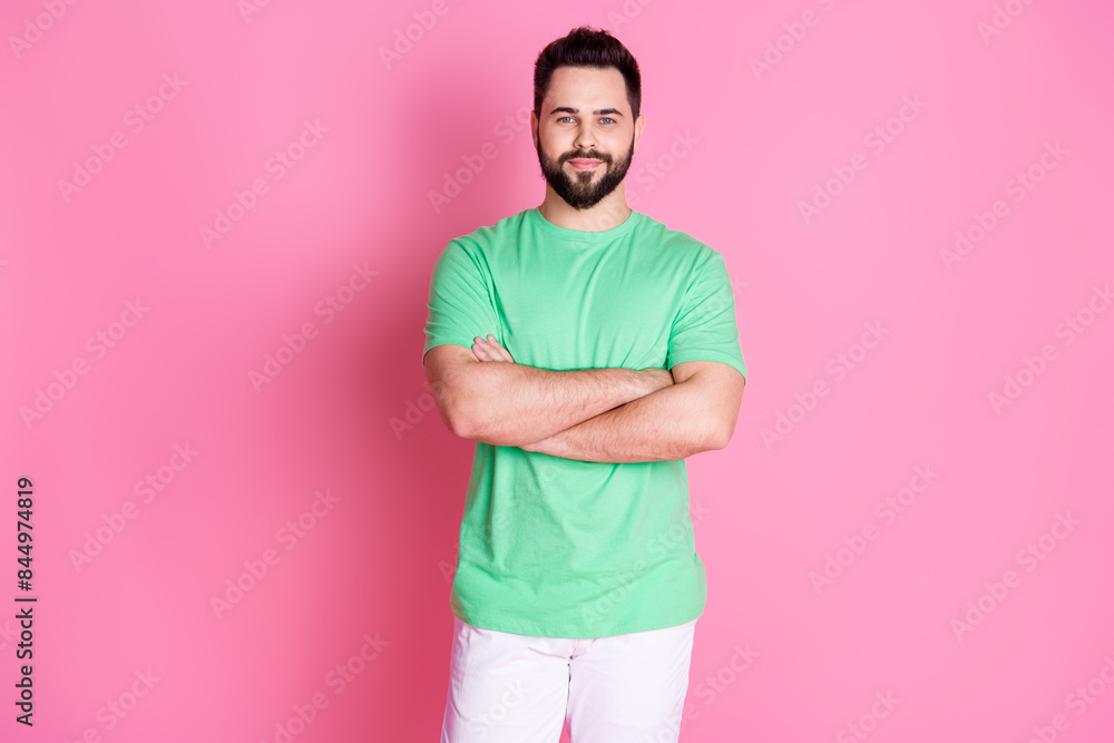 Sticker Photo of optimistic friendly guy with stylish beard dressed green t-shirt holding arms folded smiling isolated on pink color background