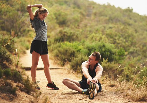 Man, woman or together with stretching break for exercise in nature, partners for collaboration or support. Couple, warm up or smile for workout in countryside for health, cardio training in Canada