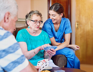 Senior woman, card game and nurse in retirement home for fun with recreational activities with...