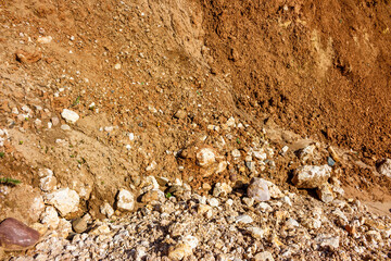 Background with crumbling stones and sliding clay on a slope