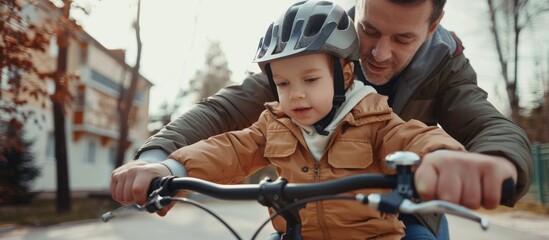 Obraz premium A man is helping a young child ride a bike