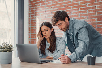 Mad millennial couple frustrated with slow Internet connection paying bills online at home,...