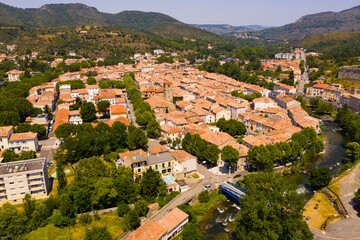 Picturesque drone view of Quillan summer cityscape on bank of river Aude looking out over ancient castle, France.