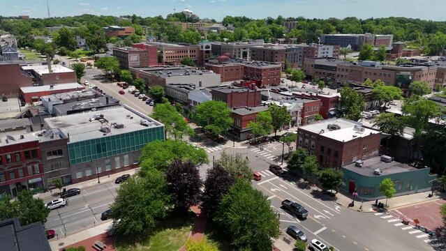 An aerial establishing shot of the small college town of Kent, Ohio on a sunny summer day. Logos on buildings have been obfuscated for general use.  	