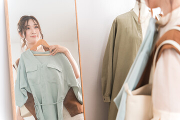 アパレルショップで洋服を買い物・ショッピングする女性
