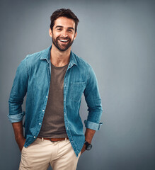 Fototapeta premium Fashion, smile and space with portrait of man in studio on gray background for relaxed clothing style. Casual, happy and mockup with natural person in clothes outfit to model jacket or wardrobe