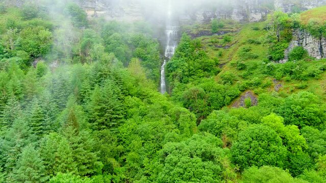 Beautiful Sruth in Aghaidh An Aird or Devil's Chimney on cloudy, foggy, rainy summer day. Ireland's tallest highest waterfall located on the Sligo and Leitrim border in the Glencar valley.